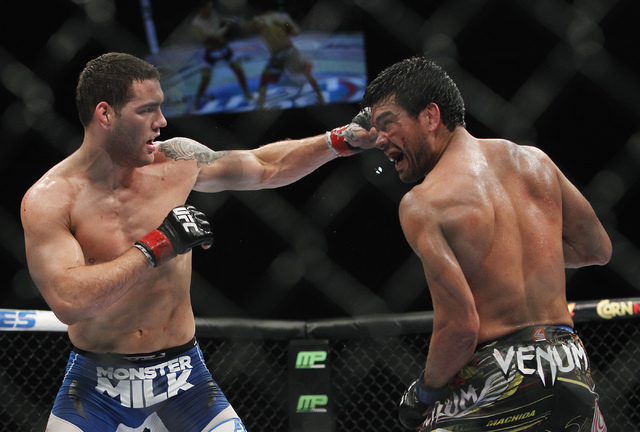 Chris Weidman, left, hits Lyoto Machida during UFC 175 at the Mandalay Bay Events Center in Las Vegas on Saturday, July 5, 2014. Weidman defeated Machida by unanimous decision to retain the Middle ...