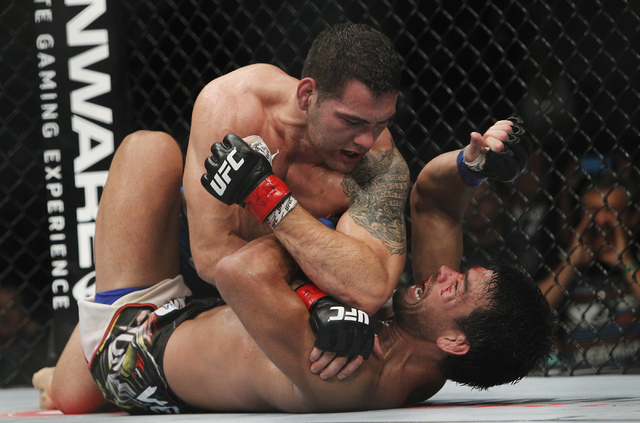 Chris Weidman, top, drops an elbow on Lyoto Machida during UFC 175 at the Mandalay Bay Events Center in Las Vegas on Saturday, July 5, 2014. Weidman defeated Machida by unanimous decision to retai ...