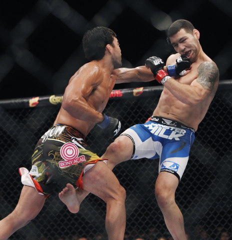 Lyoto Machida, left, hits Chris Weidman during UFC 175 at the Mandalay Bay Events Center in Las Vegas on Saturday, July 5, 2014. (Jason Bean/Las Vegas Review-Journal)