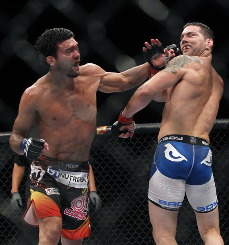 Lyoto Machida, left, hits Chris Weidman during UFC 175 at the Mandalay Bay Events Center in Las Vegas on Saturday, July 5, 2014. (Jason Bean/Las Vegas Review-Journal)
