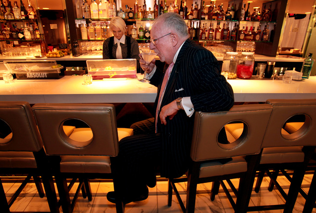 Former Las Vegas Mayor Oscar Goodman drinks a martini while bartender Tiffinie Smithe stands behind him at Oscar's Beef, Booze, Broads at the Plaza Hotel/Casino on Monday, Dec. 19, 2011. Goodman's ...