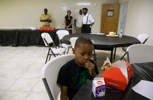 Tyler Searcy (cq), 8, eats a celery stick at Greater Evergreen Missionary Baptist Church, located at 1915 Lexington St., Wednesday, June 25, 2014. Every Tuesday, Wednesday and Thursday from 11 a.m ...