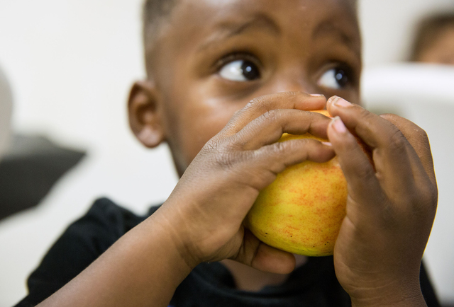 Kannon Drake (cq), 2, eats an apple at Greater Evergreen Missionary Baptist Church, located at 1915 Lexington St., Wednesday, June 25, 2014. Every Tuesday, Wednesday and Thursday from 11 a.m. to 1 ...