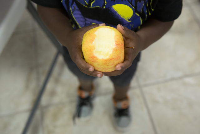 Kannon Drake (cq), 2, eats an apple at Greater Evergreen Missionary Baptist Church, located at 1915 Lexington St., Wednesday, June 25, 2014. Every Tuesday, Wednesday and Thursday from 11 a.m. to 1 ...