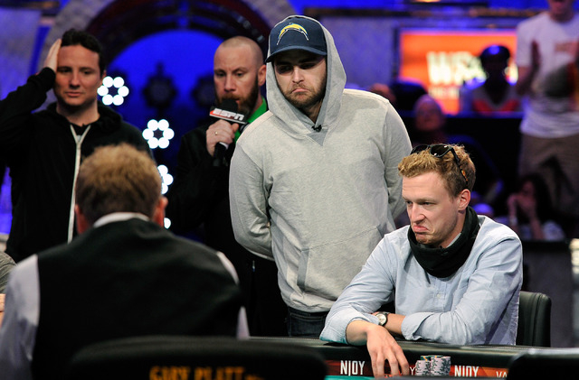 Felix Stephensen, center appears unimpressed with the flop as Bruno Politano, left , and Max Senft look on during day 7 of the World Series of Poker Main Event at the Rio hotel-casino on Monday, J ...