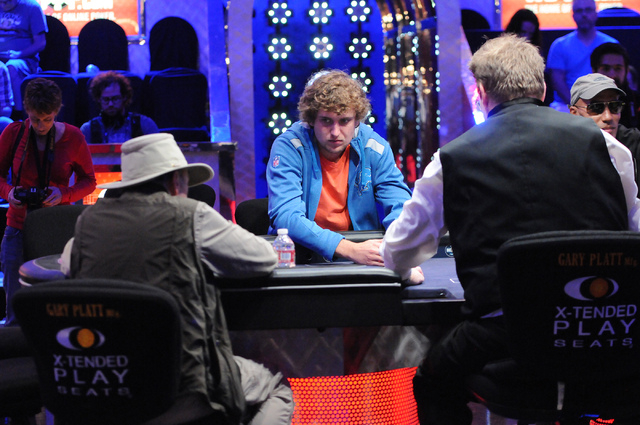 Ryan Riess, center, 2013 World Series of Poker champion, plays on the main stage inside the the Amazon room during the 2014 World Series of Poker event at the Rio Convention Center in Las Vegas Sa ...