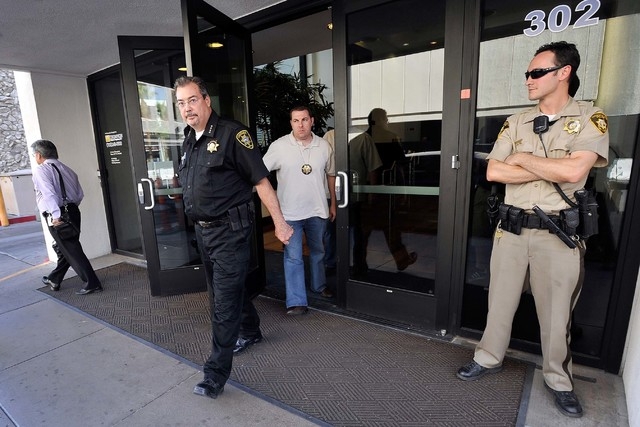 Las Vegas Constable John Bonaventura, left, exits his downtown offices as Las Vegas police look on Tuesday, June 17, 2014. Las Vegas police criminal intelligence section served search warrants in  ...