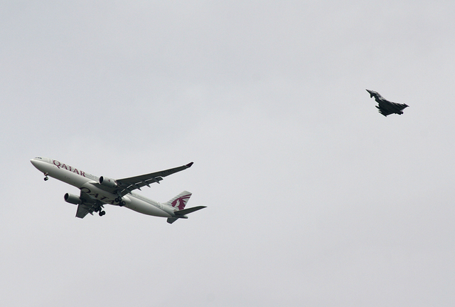 A military fighter jet escorts a passenger jet as it comes in to land at Manchester airport, Manchester, England, Tuesday, Aug. 5, 2014. Police say they have arrested a man on suspicion of making  ...
