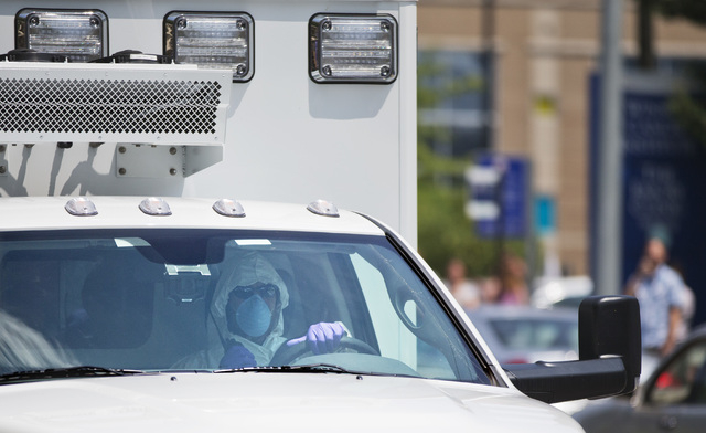 An ambulance transporting Nancy Writebol, an American missionary stricken with Ebola, arrives at Emory University Hospital, Tuesday, Aug. 5, 2014, in Atlanta. Writebol is expected to be admitted t ...