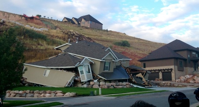 A home collapsed during a mudslide, Tuesday, Aug. 5, 2014 in North Salt Lake, Utah.  The home crumbled after rain-saturated soil from the hill above started piling up behind it at around 6 a.m. Tu ...