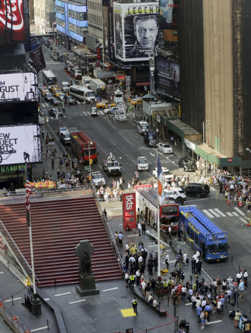 Two double-decker tour buses sit at the corner of 47th Street and 7th Avenue in Times Square after colliding, Tuesday, Aug. 5, 2014, in New York. Fire department officials said that around 13 peop ...