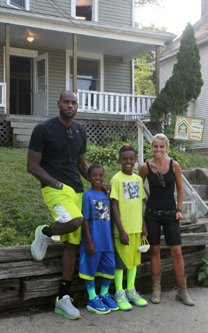 TV's Rehab Addict host Nicole Curtis, right, poses with LeBron James and his sons, LeBron Jr., and Bryce at a rehab site on Monday, Aug. 4, 2014, in Akron, Ohio.  James took the controls of a back ...