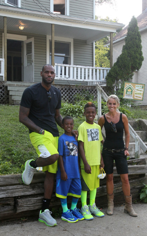 TV's Rehab Addict host Nicole Curtis, right, poses with LeBron James and his sons, LeBron Jr., and Bryce at a rehab site on Monday, Aug. 4, 2014, in Akron, Ohio. James took the controls of a back ...