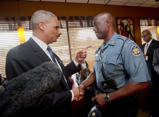 Attorney General Eric Holder talks with Capt. Ron Johnson of the Missouri State Highway Patrol at Drake's Place Restaurant, Wednesday, Aug. 20, 2014 in Florrissant, Mo. Holder arrived in Missouri ...