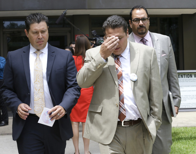 David Barajas, center, leaves the courthouse during a break in his murder trial, Wednesday, Aug. 20, 2014, in Angleton, Texas. Barajas is accused of fatally shooting Jose Banda in December 2012, m ...