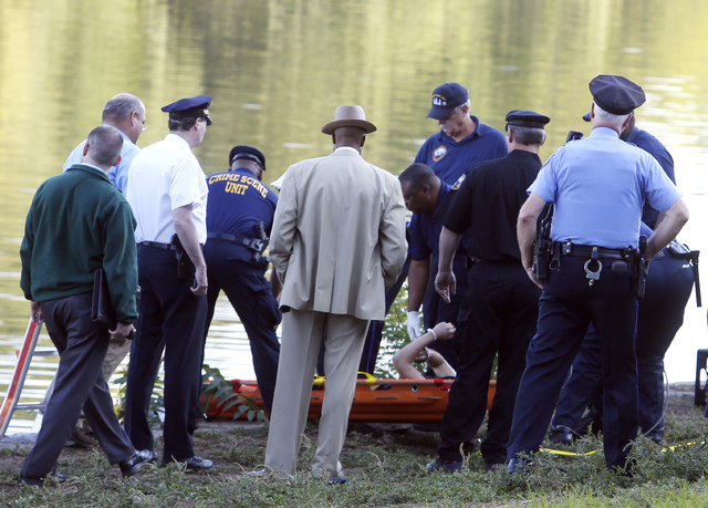 Philadelphia police and other law enforcement officials view a body pulled from the Schuylkill River in Fairmount Park in Philadelphia, Wednesday, Aug. 27, 2014. The bound bodies of two people we ...