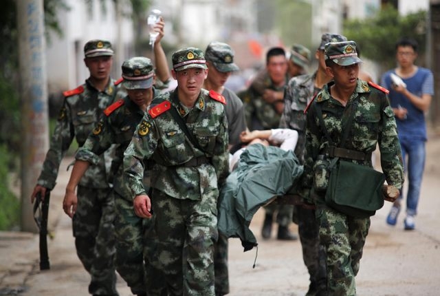 Paramilitary policemen carry an injured resident on a stretcher after an earthquake hit Ludian county of Zhaotong, Yunnan province August 3, 2014. A magnitude 6.5 earthquake struck southwestern Ch ...