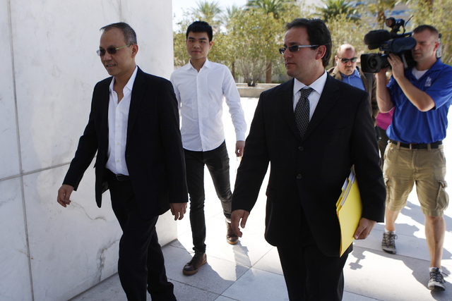 Paul Phua, left, and his son Darren, center, walk to Lloyd George Federal Courthouse in Las Vegas with their attorneys Richard Schonfeld, right, and David Chesnoff, not in the picture, for their a ...