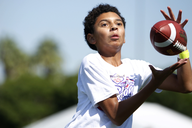 Gevon Graham, 13, makes a catch during a pass drill at the Royal Purple Las Vegas Bowl Youth Football Clinic at Bill "Wildcat" Morris Rebel Park at UNLV Tuesday, Aug. 5, 2014. (Erik Verd ...
