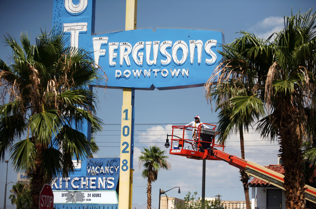 A worker operates a lift outside Fergusons Motel, located at 1028 East Fremont St. Friday, Aug. 1, 2014, in Las Vegas. Downtown Project plans to transform the closed hotel into a retail center. (R ...