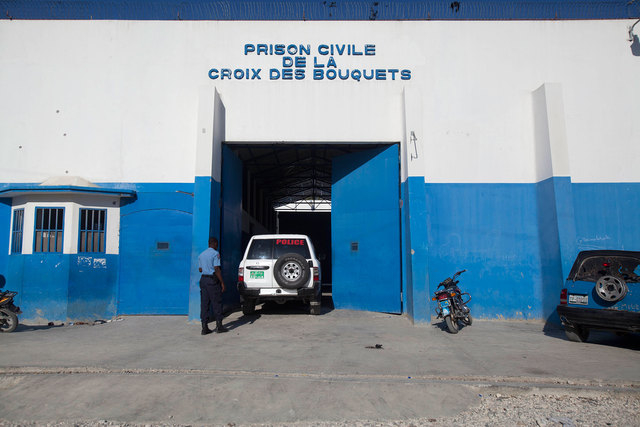 A police car goes in the principal gate of the main prison in Croix-des-Bouquets, Haiti, Monday, August 11, 2014. An attack on the prison on the outskirts of the capital to free the son of a promi ...