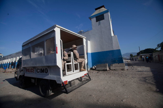 A police truck passes next to the main prison in Croix-des-Bouquets, Haiti, Monday, August 11, 2014. An attack on the prison on the outskirts of the capital to free the son of a prominent business ...