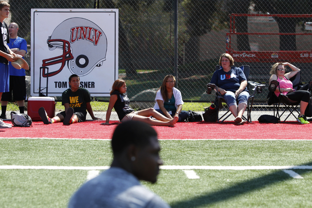 Family members watch children participating during the Royal Purple Las Vegas Bowl Youth Football Clinic at Bill "Wildcat" Morris Rebel Park at UNLV Tuesday, Aug. 5, 2014. (Erik Verduzco ...
