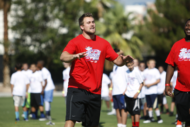 UNLV's Taylor Barnhill (16) starts a Rebels chant during the starts of the Royal Purple Las Vegas Bowl Youth Football Clinic at Bill "Wildcat" Morris Rebel Park at UNLV Tuesday, Aug. 5,  ...
