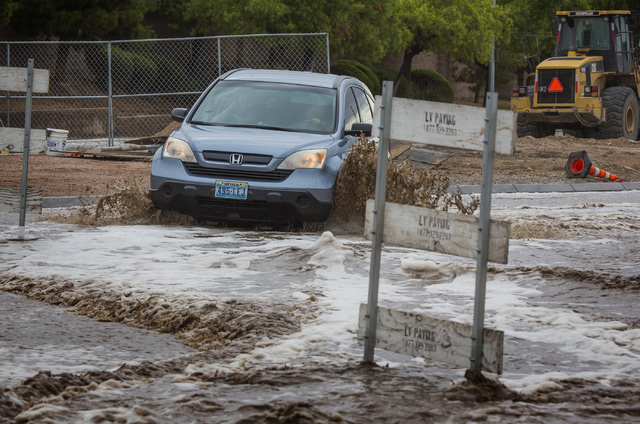 A vehicle maneuvers the  flooded Grand Teton Drive in northwest Las Vegas on Monday, Aug. 4, 2014. Overnight monsoon rains caused flooding in the area.
(Jeff Scheid/Las Vegas Review-Journal)