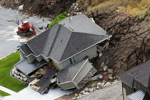 A home is damaged by a mudslide, Tuesday, Aug. 5, 2014 in North Salt Lake, Utah.  The home crumbled after rain-saturated soil from the hill above started piling up behind it at around 6 a.m. Tuesd ...
