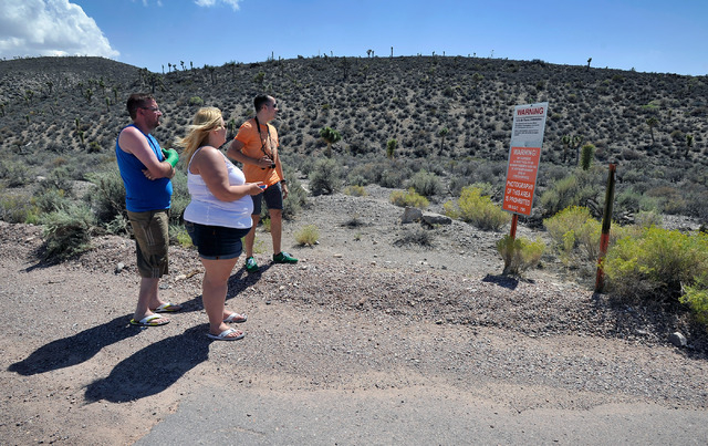 Tourists, from left, Shane Cooper and his wife, Becky Cooper, of England and Floris Otten of The Netherlands, visit the perimeter of the well guarded military installation on Tuesday, Aug. 5, 201 ...