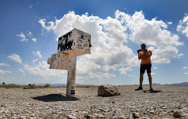 Floris Otten, of The Netherlands photographs the famous black mailbox along Nevada Highway 375 or Extraterrestrial Highway, on Tuesday, Aug. 5, 2014. The mailbox, which is now white and owned by a ...