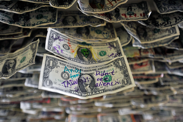 Messages on dollar bills are seen above the bar at the Little A'Le'Inn in Rachel, Nev. on Tuesday, Aug. 5, 2014. Visitors from around the globe stop at the little town of Rachel and visit the heav ...