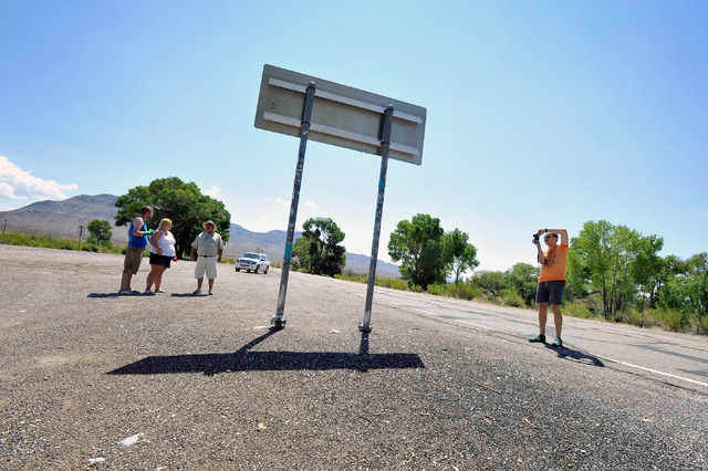 Tourist Floris Otten, right, of The Netherlands, snaps a photo of the Extraterrestrial Highway sign as he and other tourists, from left, Shane Cooper and his wife, Becky Cooper, of England, visite ...