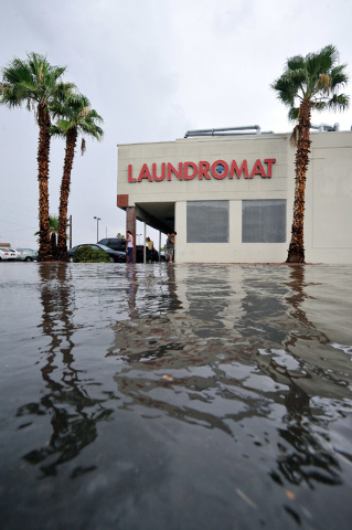 Flood waters strand people in front of a laundromat near on Montclair Street near Charleston Boulevard on Monday, Aug. 4, 2014. (Photo by David Becker/Las Vegas Review Journal)