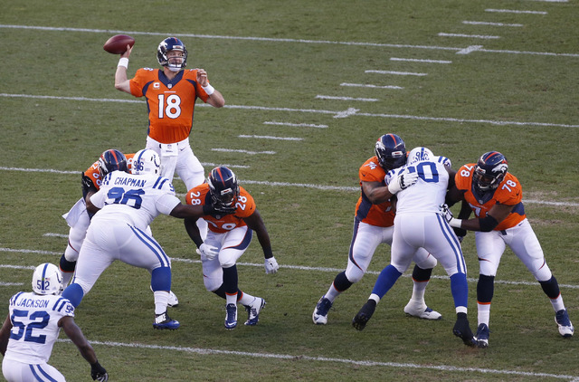 Denver Broncos quarterback Peyton Manning (18) throws against the Indianapolis Colts during the first half of an NFL football game, Sunday, Sept. 7, 2014, in Denver. (AP Photo/Brennan Linsley)