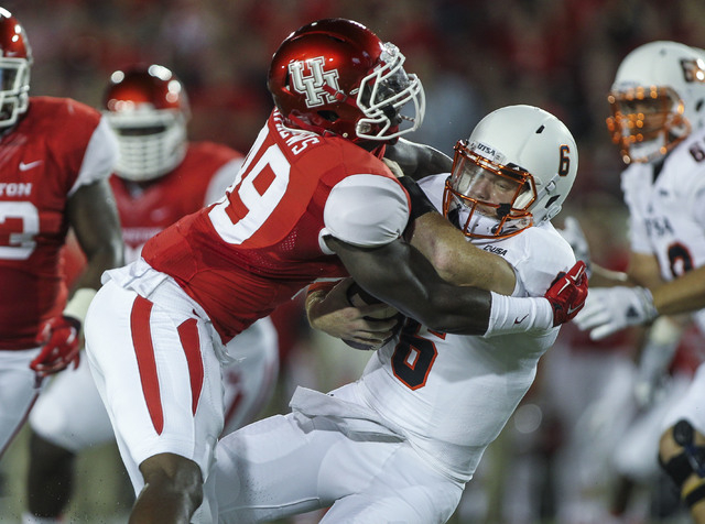Aug 29, 2014; Houston, TX, USA; Houston Cougars linebacker Derrick Mathews (49) tackles UTSA Roadrunners quarterback Tucker Carter (6) for a loss during the first quarter at TDECU Stadium. (Troy T ...