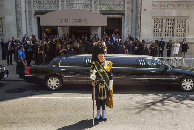 A member of a bagpipe ensemble looks on as mourners depart the funeral of comedian Joan Rivers at Temple Emanu-El in New York September 7, 2014. REUTERS/Lucas Jackson (UNITED STATES - Tags: ENTERT ...