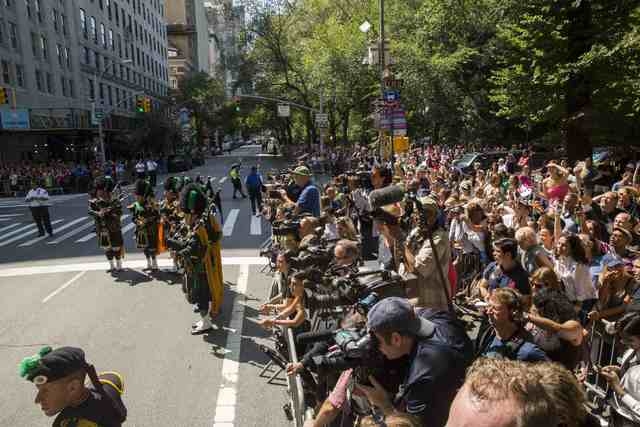 Member of a bagpipe ensemble perform as members of the media and fans watch mourners depart the funeral of comedian Joan Rivers at Temple Emanu-El in New York September 7, 2014. REUTERS/Lucas Jack ...