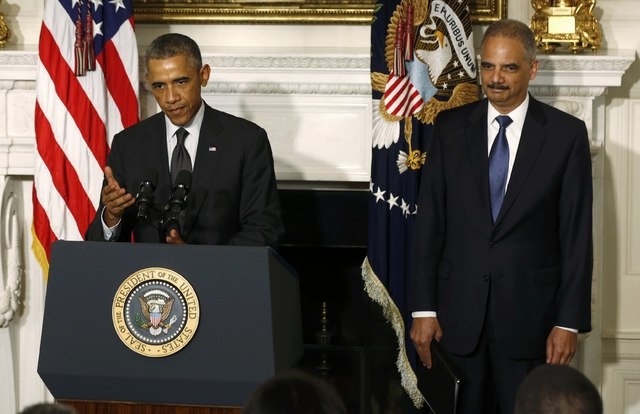 U.S. President Barack Obama, left, announces the resignation of Attorney General Eric Holder in the White House State Dining Room in Washington, Thursday, Sept. 25, 2014. (Reuters/Larry Downing)
