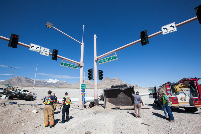 Nevada Highway Patrol and Las Vegas Fire and Rescue officials respond to a crash involving two landscaping trucks that caused one to catch fire at the Summerlin Parkway and 215 Beltway intersectio ...