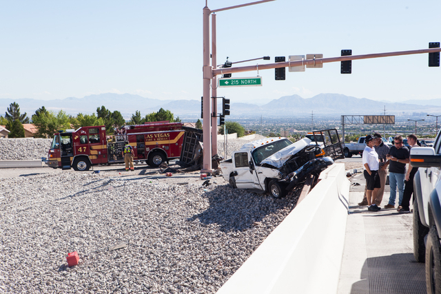 Nevada Highway Patrol and Las Vegas Fire and Rescue officials respond to a crash involving two landscaping trucks that caused one to catch fire at the Summerlin Parkway and 215 Beltway intersectio ...