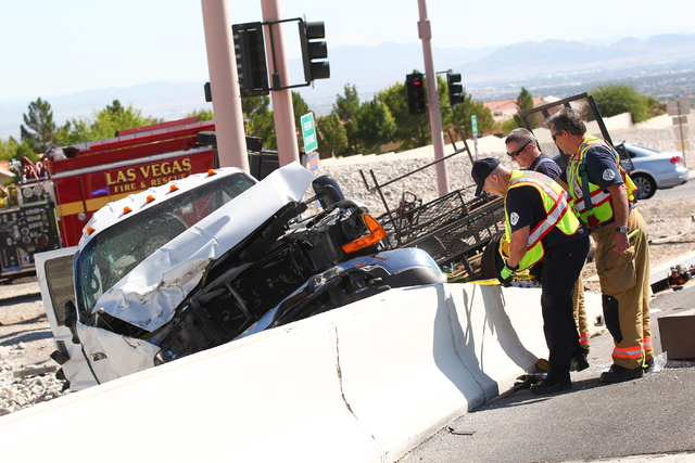 Nevada Highway Patrol and Las Vegas Fire and Rescue officials respond to a crash involving two landscaping trucks that caused one to catch fire at the Summerlin Parkway and 215 Beltway intersectio ...