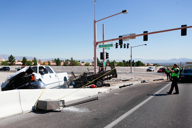 Nevada Highway Patrol officers respond to a crash involving two landscaping trucks that caused one to catch fire at the Summerlin Parkway and 215 Beltway intersection in Las Vegas on Wednesday, Se ...