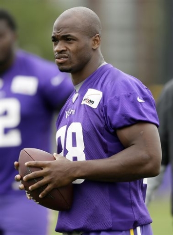 In this July 28, 2014, file photo,Minnesota Vikings running back Adrian Peterson looks on during NFL football training camp in Mankato, Minn.  After a day of public pressure from angry fans and co ...