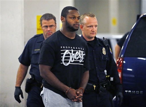Phoenix police officers escort Arizona Cardinals running back Jonathan Dwyer,  to the 4th Avenue Jail following his arrest, Wednesday, Sept. 17, 2014 in Phoenix. Arizona Cardinals running back Jon ...