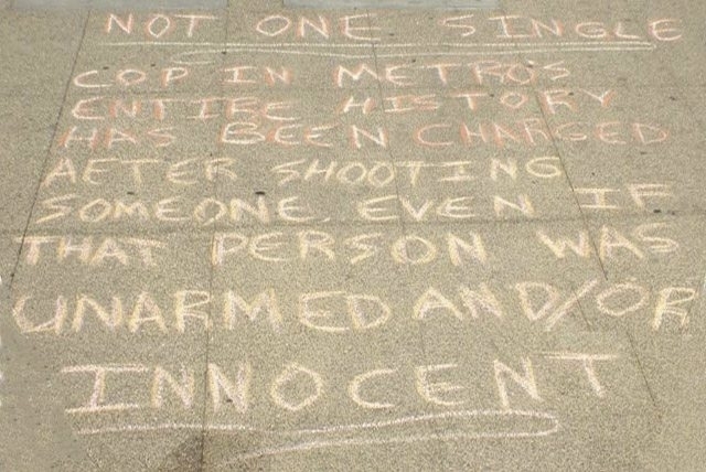 Four protesters have been charged in connection with messages written in chalk outside the Metropolitan Police Departments headquarters and in front of the Regional Justice Center. The one above ...