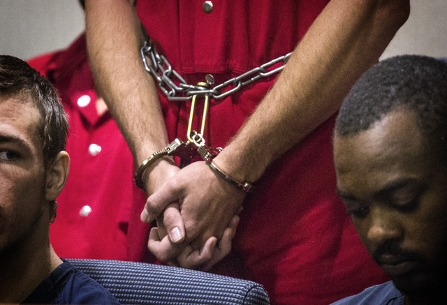 Michael Boyd Jr., 19, in handcuffs, appears in Henderson Justice Court on Wednesday, Sept. 3, 2014. He is charged with felonies for putting a barrel of fuel on a bonfire that exploded and led to ...