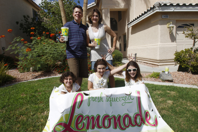 Rock Rocheleau, clockwise from back left, his wife Stacy, and daughters Jenna, 12, Jordan 12, and Stacy, 10, pose for a portrait with their lemonade sign at their home in Henderson Saturday, Sept. ...