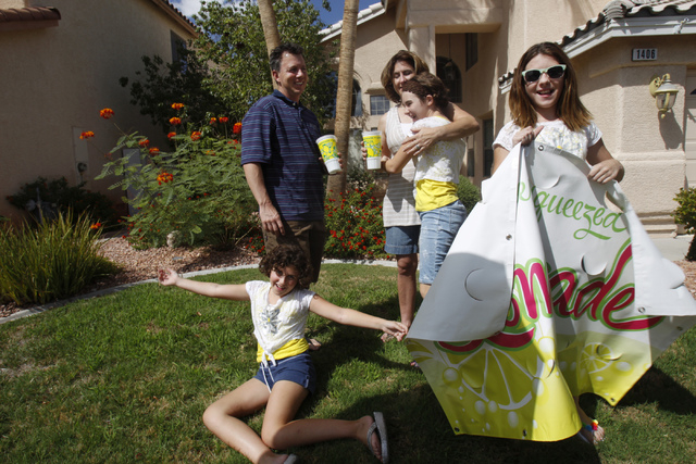 Rock Rocheleau, clockwise from back left, his wife Stacy, and daughters Jordan, 12, Jenna 12, and Stacy, 10, pose for a portrait with their lemonade sign at their home in Henderson Saturday, Sept. ...